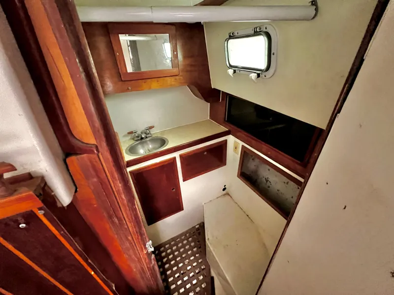 Slide: The Image of 1974 Irwin 37 Center Cockpit bathroom with sink, mirror, and porthole window. - 34