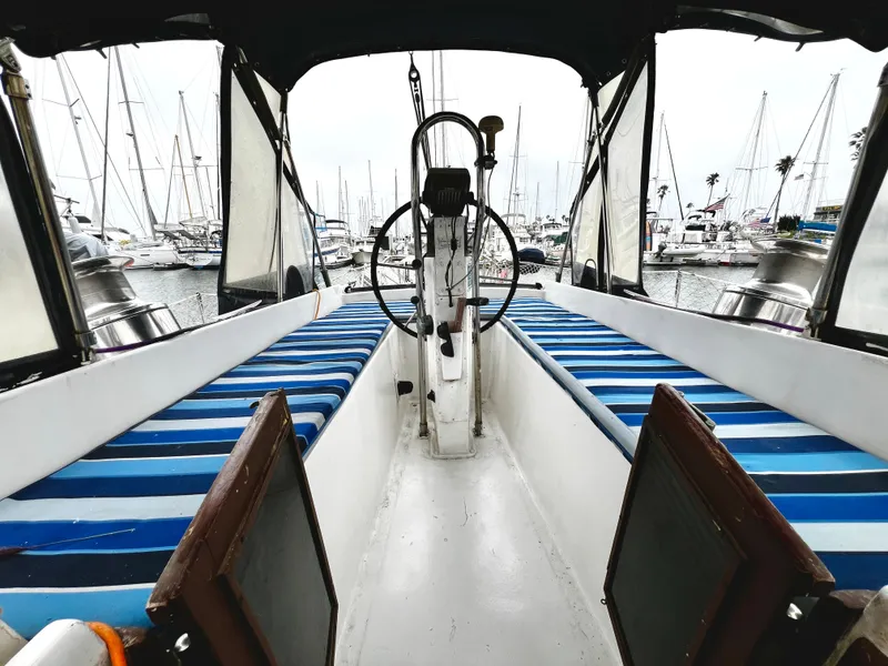 Slide: The Image of 1974 Irwin 37 Center Cockpit sailboat interior with striped seating, docked at marina. - 36