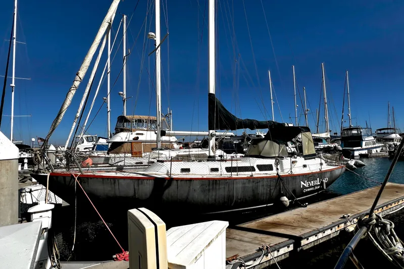 Slide: The Image of 1974 Irwin 37 Center Cockpit sailboat docked at marina under clear blue sky. - 37