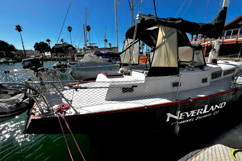 Slide: The Image of 1974 Irwin 37 Center Cockpit sailboat docked, named "Neverland," in a sunny marina setting. - 39