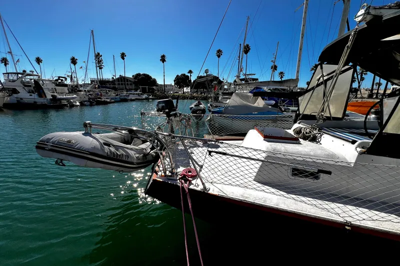 Slide: The Image of 1974 Irwin 37 Center Cockpit sailboat docked in a sunny marina with palm trees. - 40