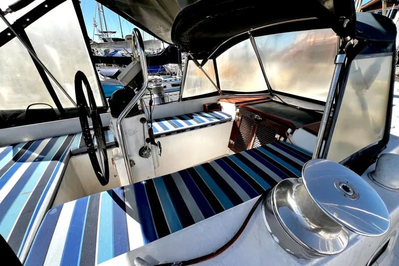 Slide: The Image of 1974 Irwin 37 Center Cockpit with striped seating and steering wheel, docked at marina. - 42