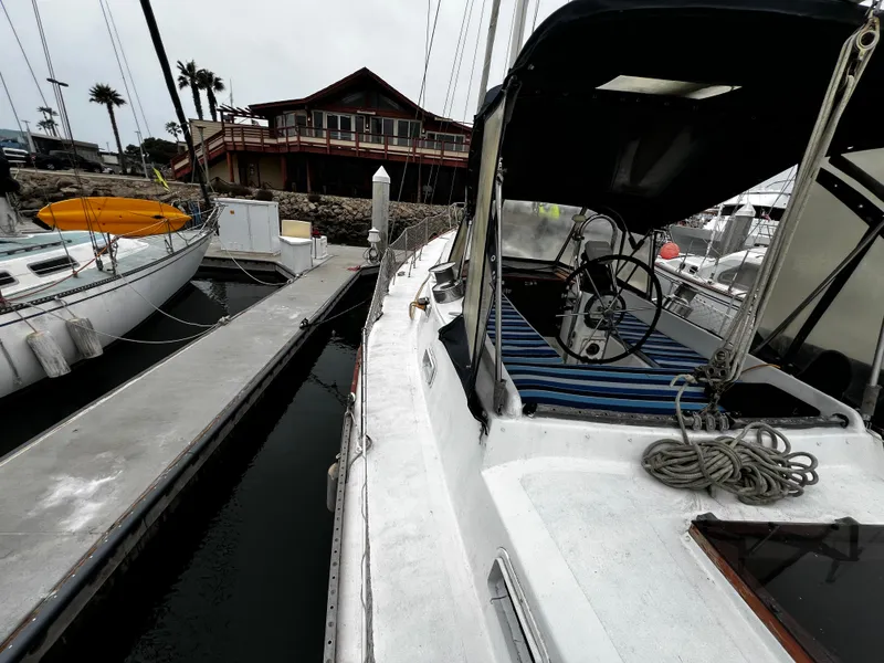 Slide: The Image of 1974 Irwin 37 Center Cockpit sailboat docked at marina with nearby building. - 5