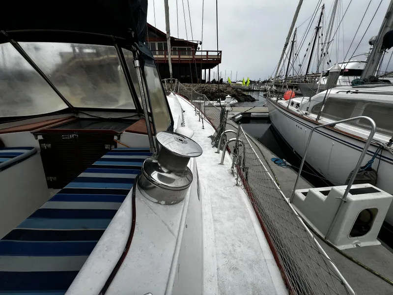 Slide: The Image of 1974 Irwin 37 Center Cockpit sailboat docked at marina, featuring striped seating and winch. - 7