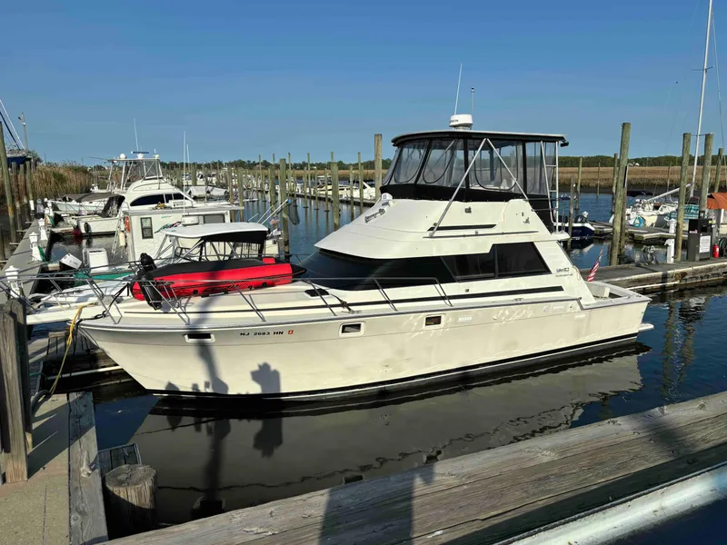 Slide: The Image of 1988 Luhrs Tournament 400 Convertible boat docked at a marina under clear blue skies. - 1