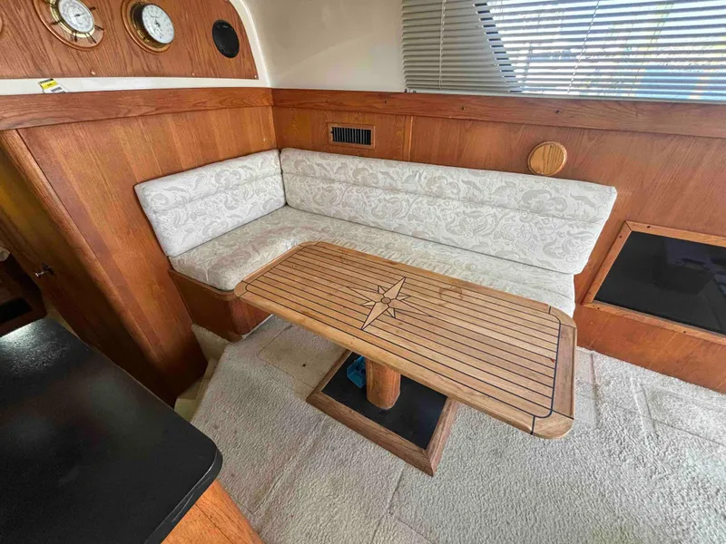 Slide: The Image of 1988 Luhrs Tournament 400 Convertible interior with wooden table and cushioned seating. - 10