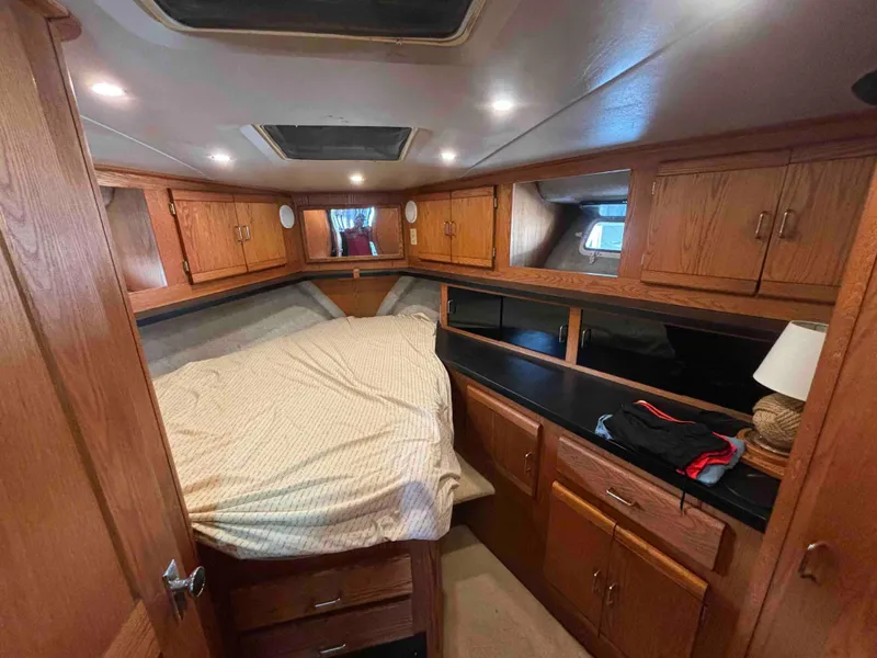 Slide: The Image of 1988 Luhrs Tournament 400 Convertible cabin with wood cabinetry and cozy bed. - 11