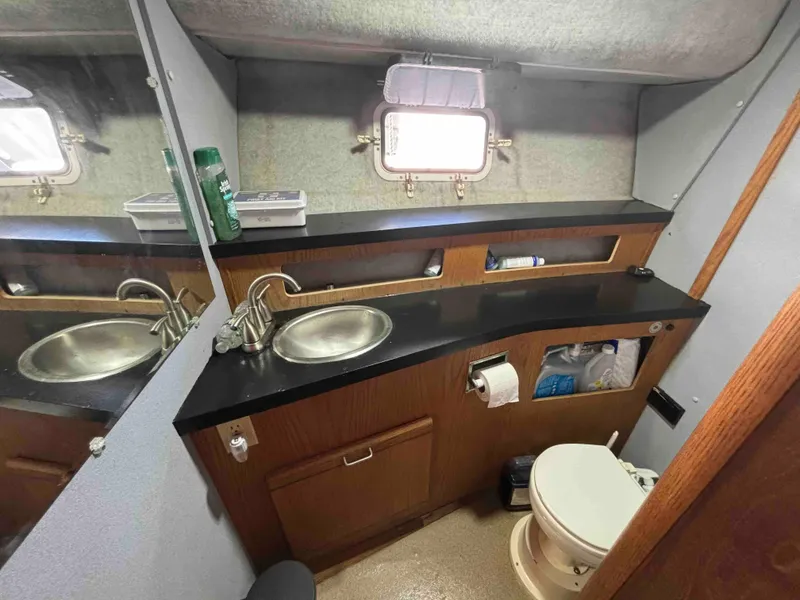 Slide: The Image of 1988 Luhrs Tournament 400 Convertible bathroom with sink, mirror, and toilet. - 12