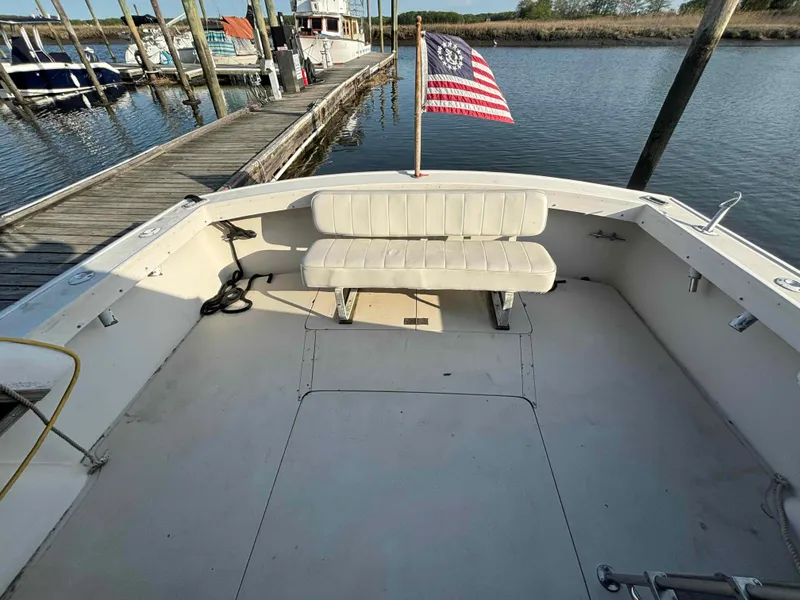 Slide: The Image of 1988 Luhrs Tournament 400 Convertible boat with American flag at dock. - 6