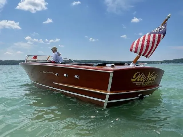 Slide: The Image of 1956 Chris-Craft 23 Continental boat on clear water, American flag waving. - 19