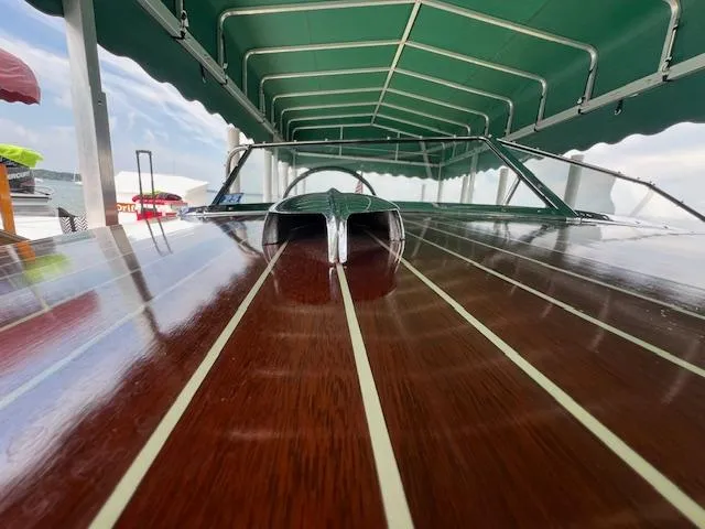 Slide: The Image of 1956 Chris-Craft 23 Continental boat with polished wooden deck under green canopy. - 33