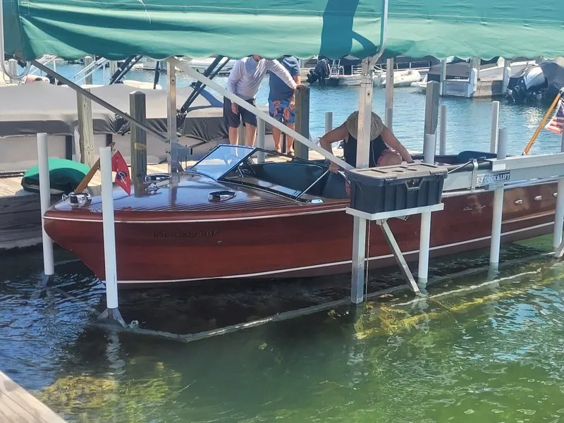 Slide: The Image of 1956 Chris-Craft 23 Continental boat docked under a green canopy. - 35