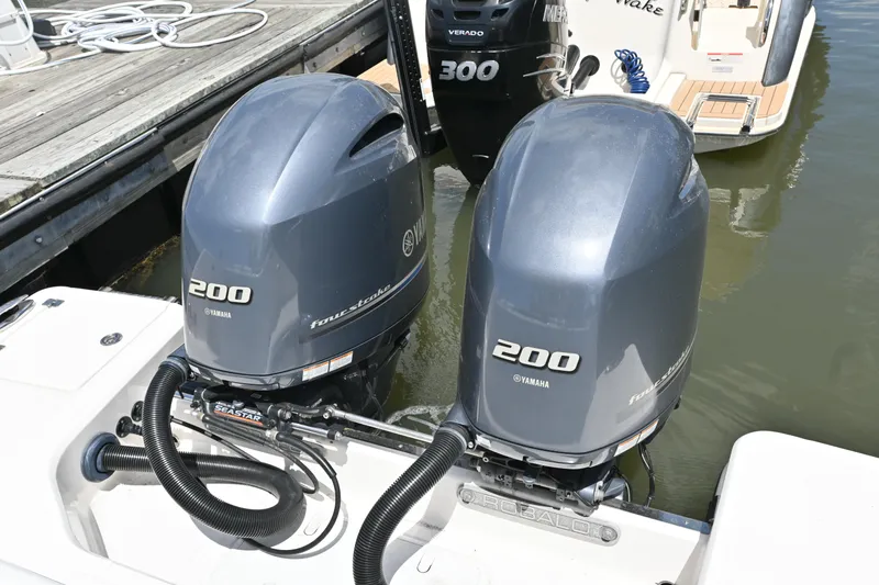 Slide: The Image of Twin Yamaha 200 engines on a 2020 Robalo R272 Center Console boat at a dock. - 13