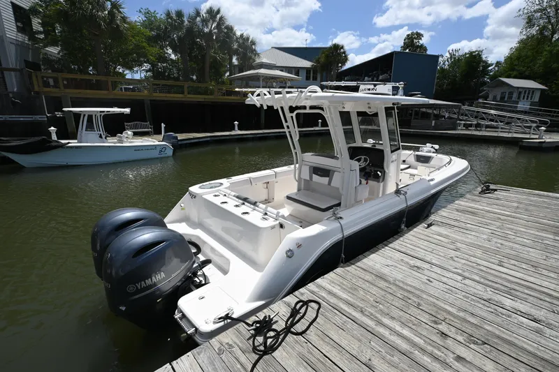 Slide: The Image of 2020 Robalo R272 Center Console boat docked with twin Yamaha engines. - 14
