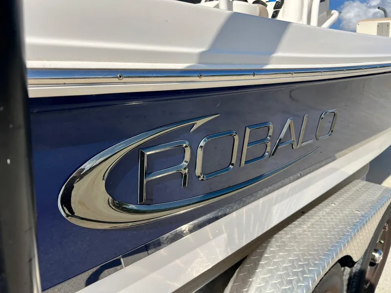 Slide: The Image of 2022 Robalo 206 Cayman boat side view with logo and trailer. - 2