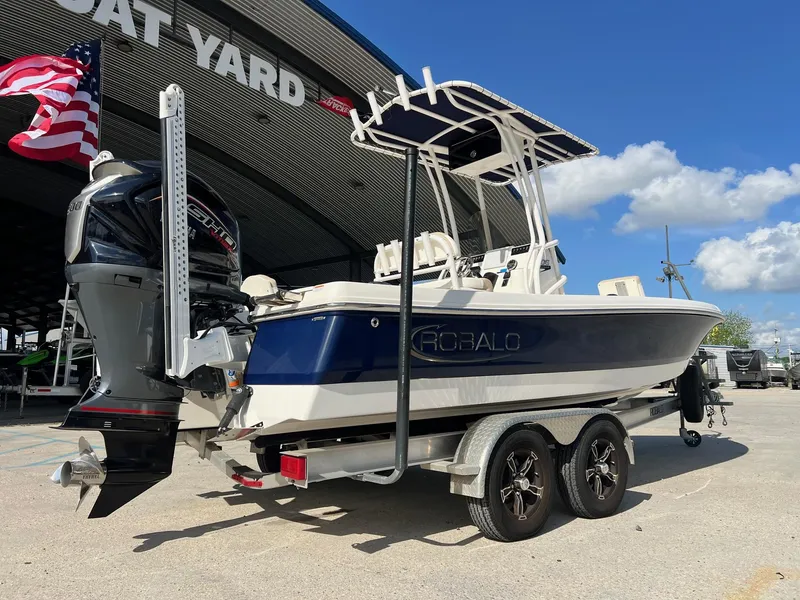Slide: The Image of 2022 Robalo 206 Cayman boat on trailer at boat yard, American flag visible. - 3