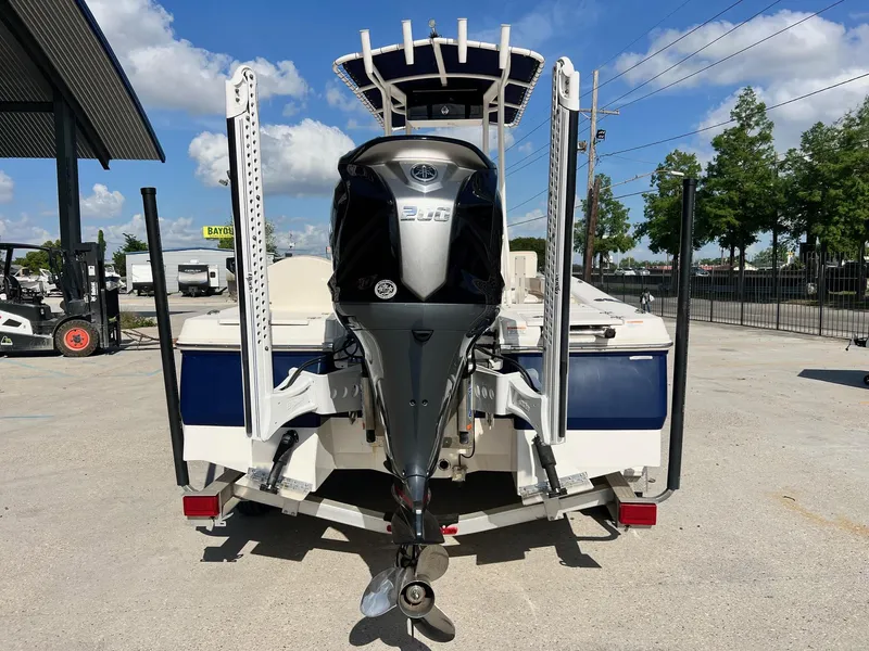 Slide: The Image of 2022 Robalo 206 Cayman boat with outboard motor, parked outdoors on a sunny day. - 4