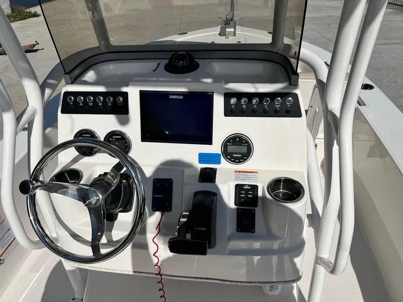 Slide: The Image of 2022 Robalo 206 Cayman boat dashboard with steering wheel and electronic controls. - 8