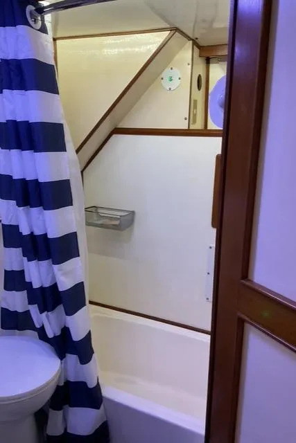 Slide: The Image of Bathroom interior of 1988 Jefferson 42 Sundeck yacht with striped shower curtain. - 22