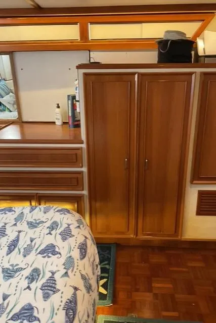 Slide: The Image of Interior of 1988 Jefferson 42 Sundeck with wooden cabinets and nautical-themed bedding. - 28