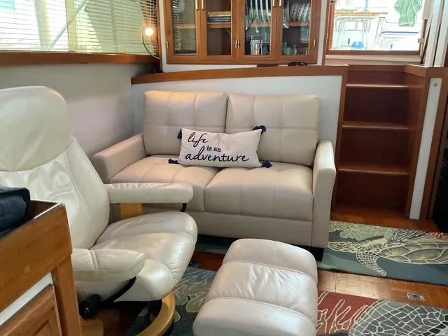 Slide: The Image of Cozy interior of 1988 Jefferson 42 Sundeck with white seating and adventure-themed pillow. - 29