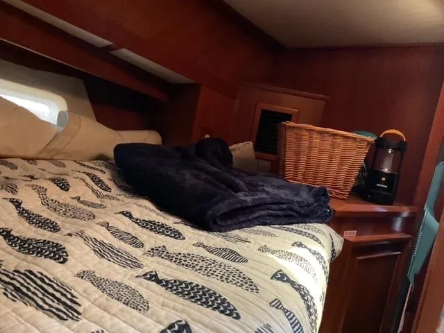 Slide: The Image of Cozy cabin interior of 1988 Jefferson 42 Sundeck with patterned bedding and wicker basket. - 3