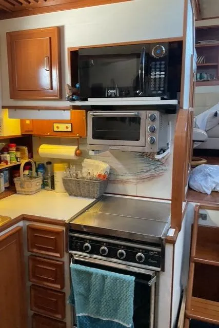 Slide: The Image of 1988 Jefferson 42 Sundeck kitchen with microwave, oven, and wooden cabinetry. - 46