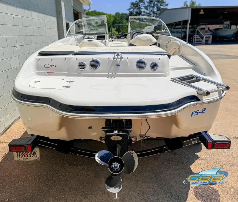 Slide: The Image of 2007 Tahoe Q7i SF boat, rear view, parked outdoors with visible propeller and license plate. - 3