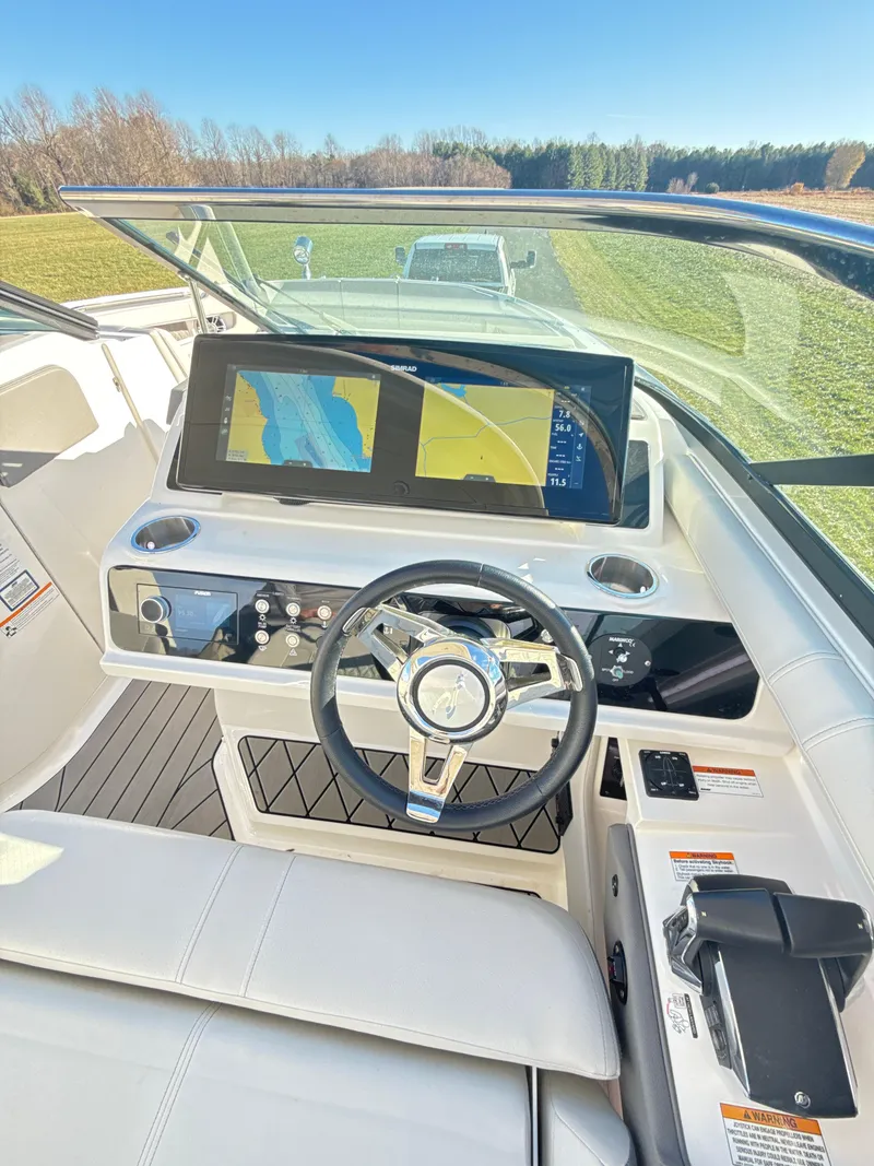 Slide: The Image of 2023 Sea Ray SLX 310 OB boat dashboard with modern navigation system and steering wheel. - 10