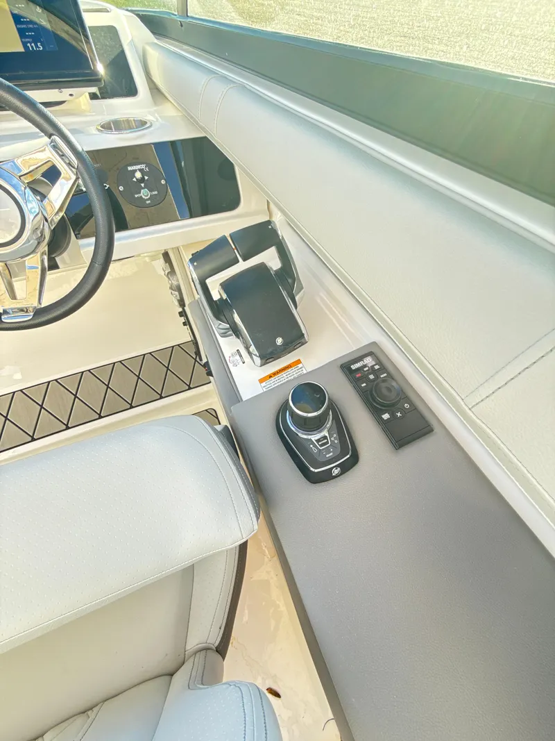 Slide: The Image of 2023 Sea Ray SLX 310 OB helm with modern controls and steering wheel. - 20
