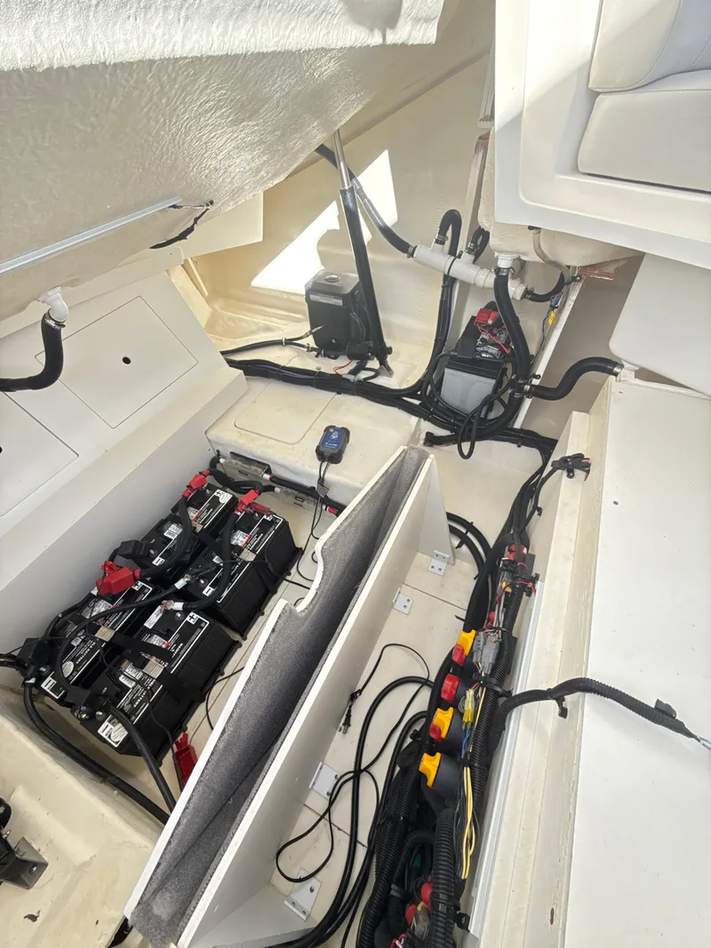 Slide: The Image of 2023 Sea Ray SLX 310 OB boat interior showing battery and wiring setup. - 27