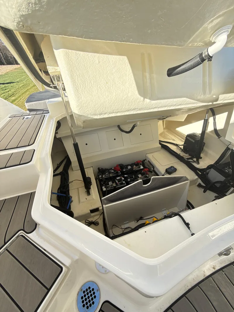 Slide: The Image of 2023 Sea Ray SLX 310 OB boat storage compartment with open hatch, showcasing interior details. - 31