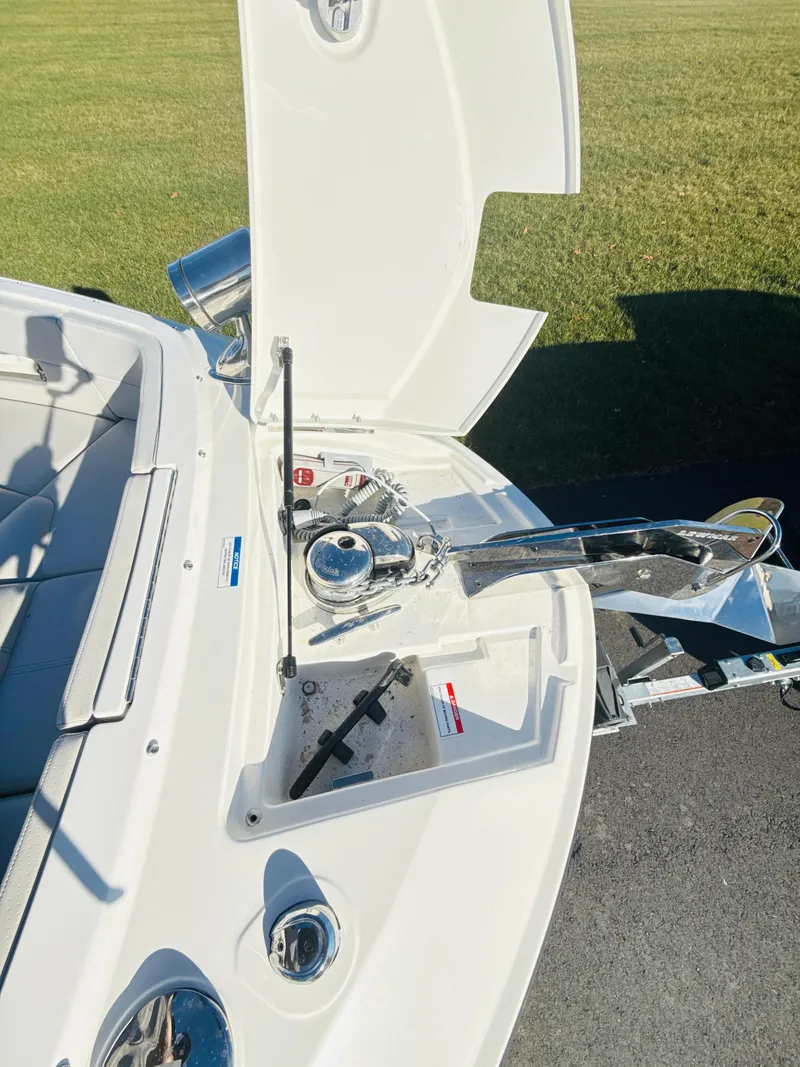 Slide: The Image of 2023 Sea Ray SLX 310 OB boat anchor compartment open, showcasing sleek design and functionality. - 34
