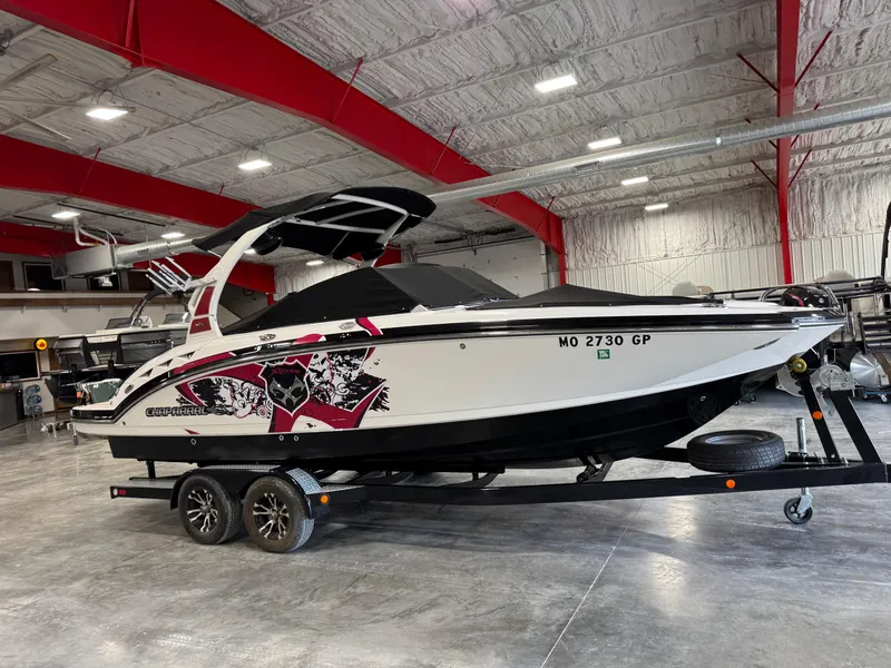 Slide: The Image of 2012 Chaparral 244 EXTREME boat in indoor showroom, on trailer, with vibrant graphics. - 12