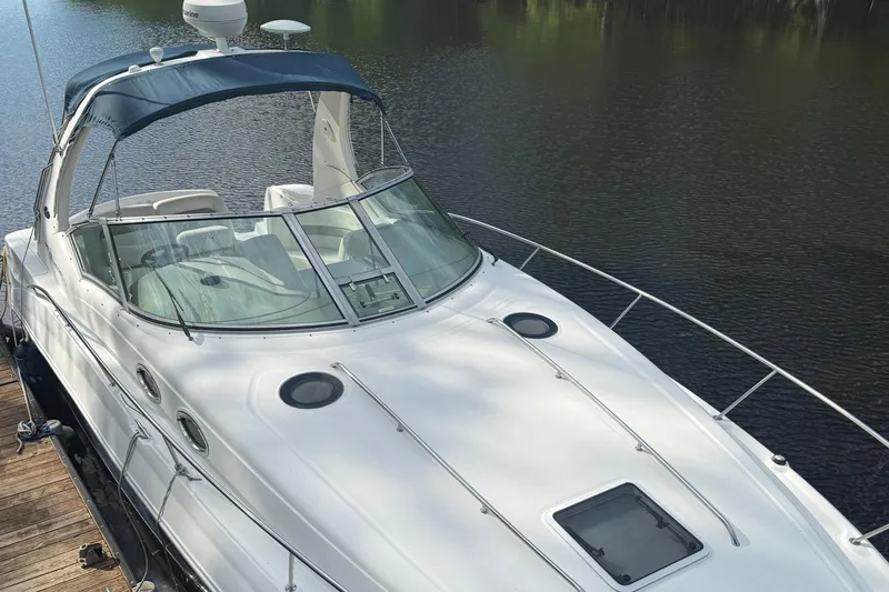 Slide: The Image of 2004 Sea Ray 320 Sundancer yacht docked on calm water. - 1