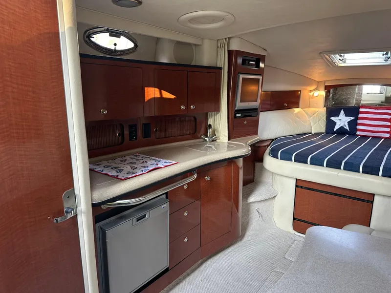 Slide: The Image of Interior of 2004 Sea Ray 320 Sundancer with kitchenette and cozy sleeping area. - 12