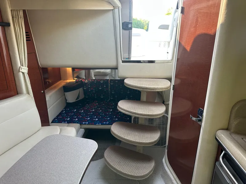 Slide: The Image of Interior of 2004 Sea Ray 320 Sundancer with stairs, seating, and table. - 13
