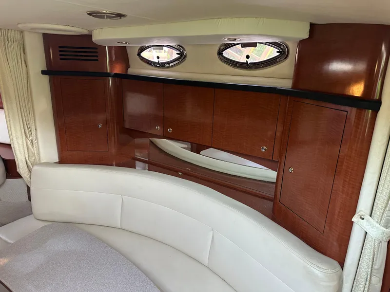 Slide: The Image of Interior of 2004 Sea Ray 320 Sundancer with wood cabinets and curved seating. - 16
