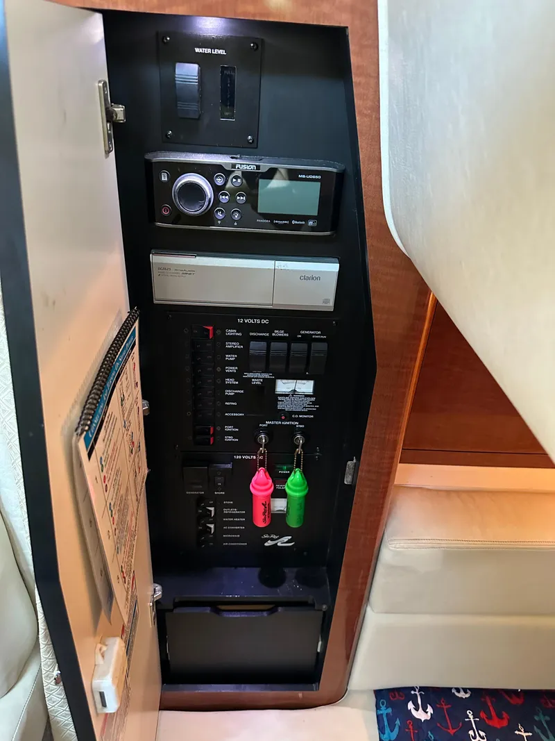 Slide: The Image of Electrical panel inside 2004 Sea Ray 320 Sundancer boat, featuring control switches and equipment. - 19