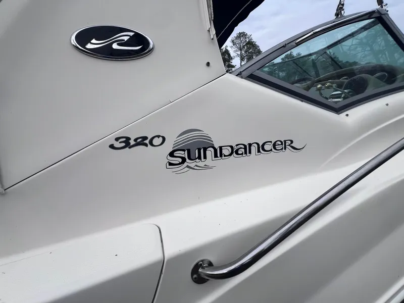 Slide: The Image of 2004 Sea Ray 320 Sundancer boat exterior with logo and model name. - 5