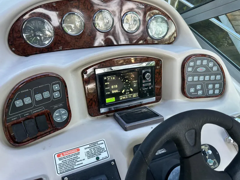 Slide: The Image of Dashboard of a 2004 Sea Ray 320 Sundancer boat with navigation controls and gauges. - 8