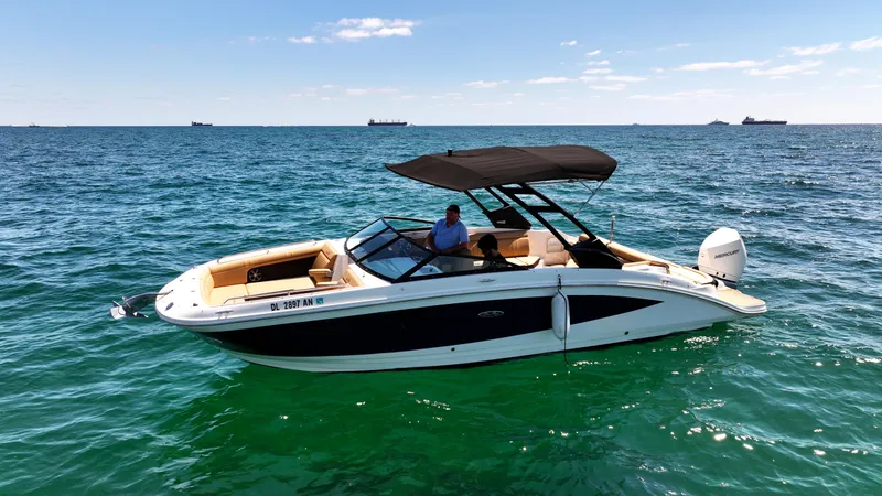 Slide: The Image of 2021 Sea Ray SDX 270 boat cruising on open water under clear skies. - 0