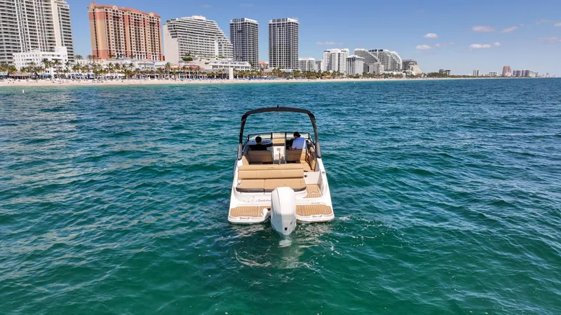 Slide: The Image of 2021 Sea Ray SDX 270 boat cruising near a city skyline on a sunny day. - 10