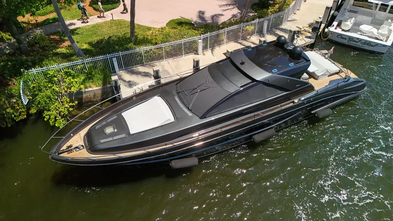 Slide: The Image of A sleek black yacht docked in a marina, surrounded by lush greenery. - 20