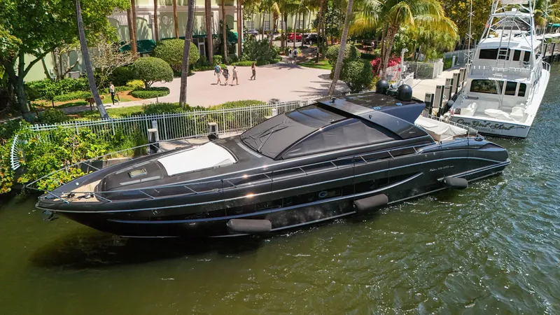 Slide: The Image of Luxurious black yacht docked in a marina, surrounded by lush greenery and palm trees. - 21