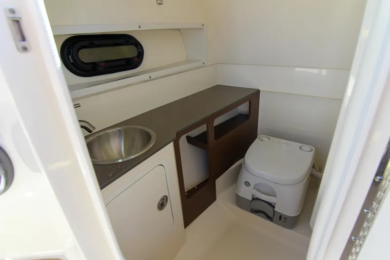 Slide: The Image of 2021 Sea Ray SDX 270 boat bathroom with sink, toilet, and window. - 26