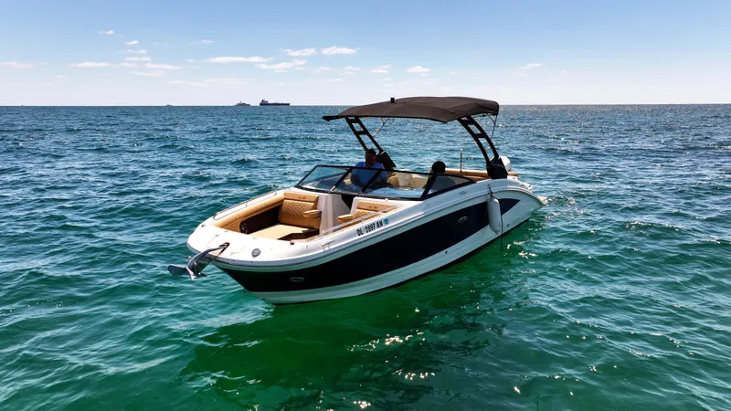 Slide: The Image of 2021 Sea Ray SDX 270 boat cruising on open water under clear skies. - 3
