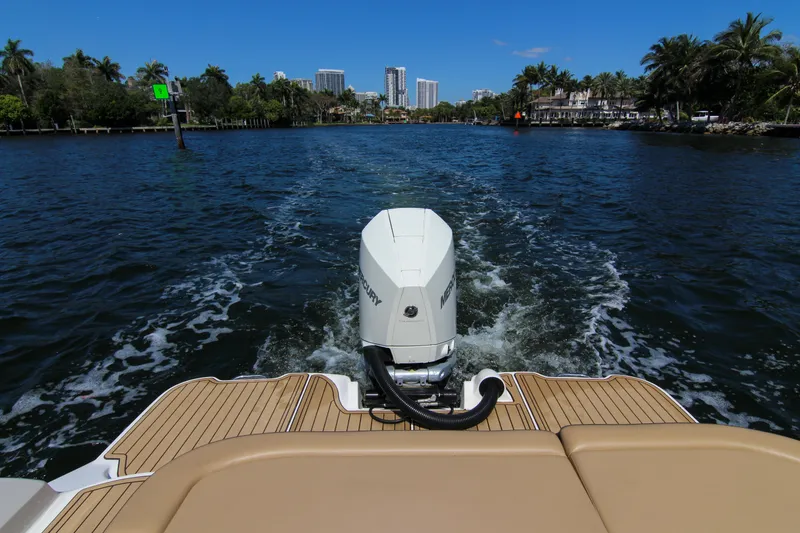 Slide: The Image of 2021 Sea Ray SDX 270 cruising on a scenic waterway with city skyline in the background. - 30