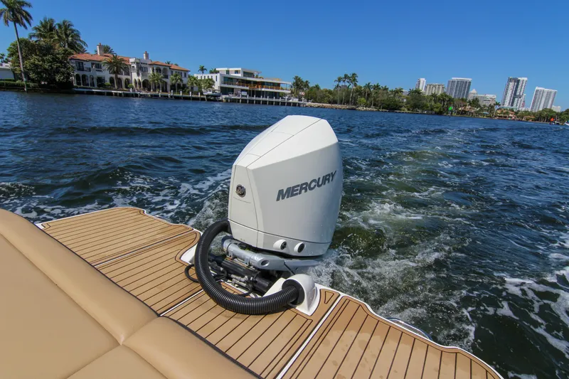 Slide: The Image of 2021 Sea Ray SDX 270 boat with Mercury outboard engine on water, cityscape in background. - 32