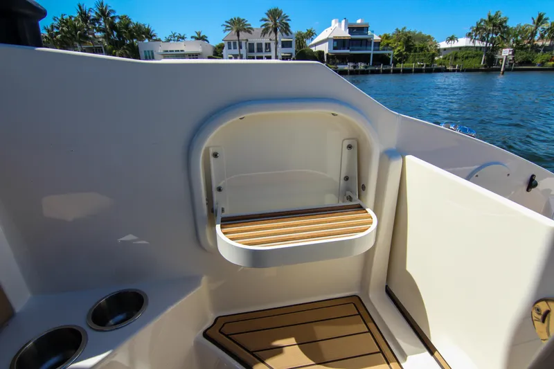 Slide: The Image of 2021 Sea Ray SDX 270 boat interior with seating and cup holders by the water. - 36